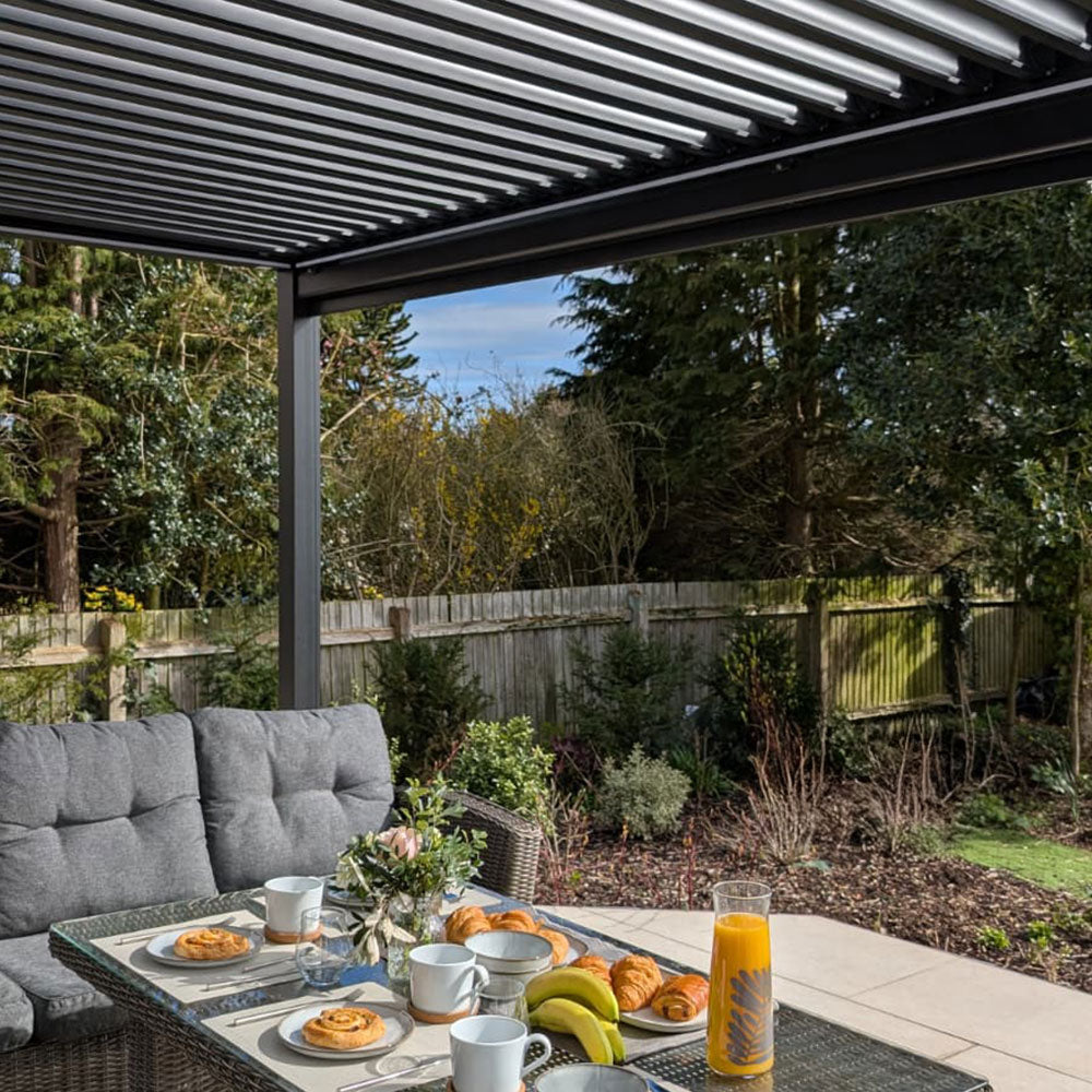 Aluminium pergola patio with outdoor dining furniture and garden setting